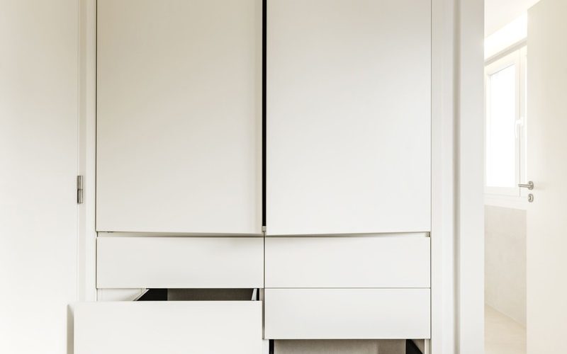 una-habitacion-recientemente-renovada-con-armarios-de-madera-blanca-con-puertas-abiertas